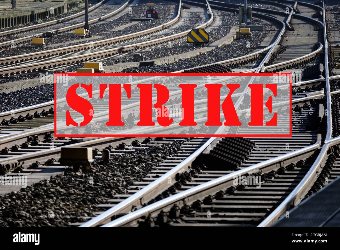 Banner with text STRIKE over lots of railroad tracks and switches, trade union concept for fair pay and working conditions in the transport sector, se Stock Photo