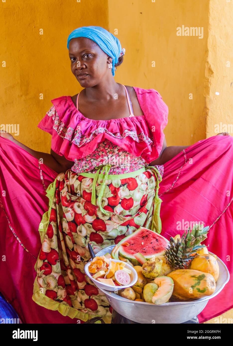 CARTAGENA DE INDIAS, COLOMBIA - AUG 28, 2015: Woman wearing traditional costume sells fruits in the center of Cartagena. Stock Photo