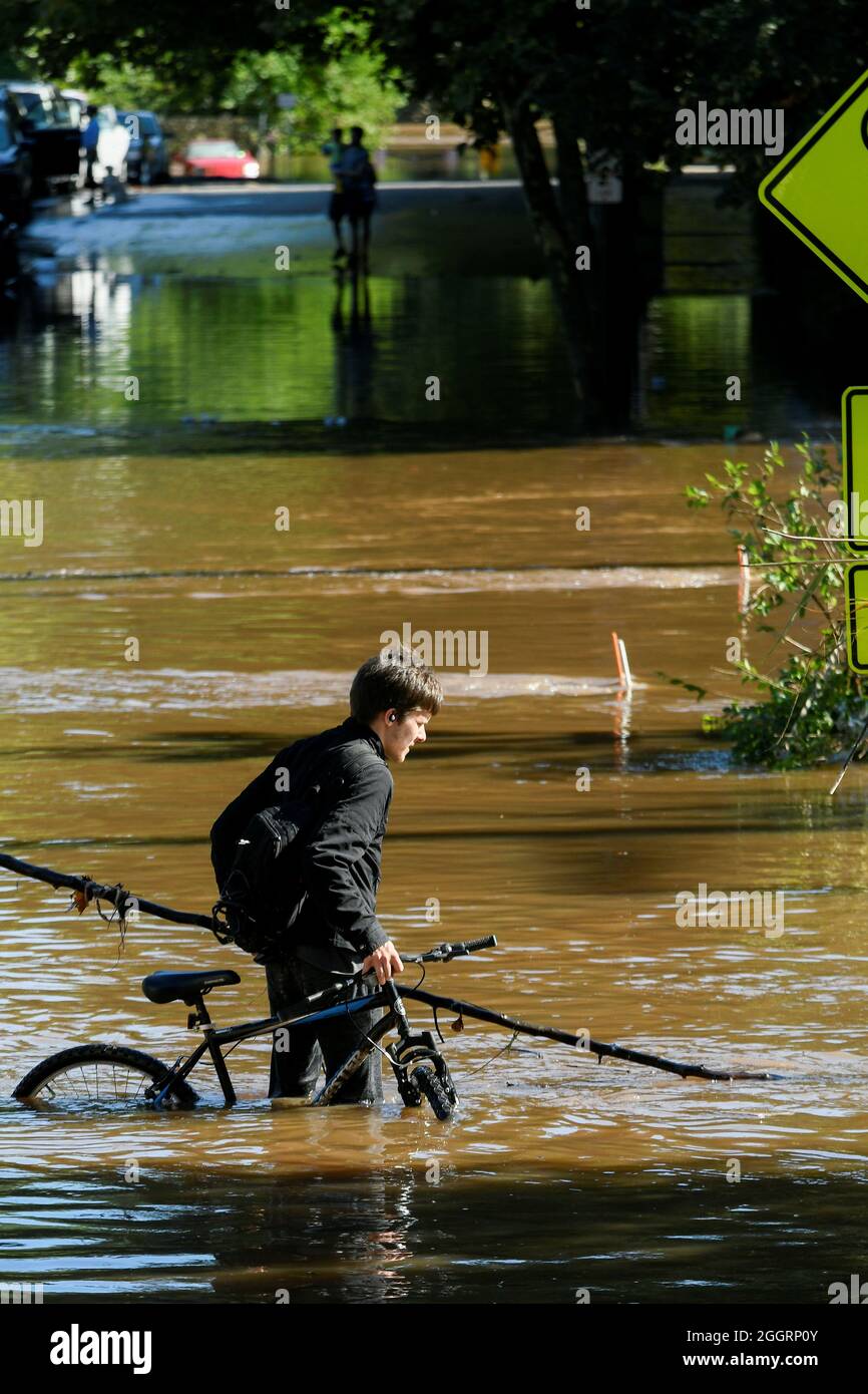 People maneuver floodwaters caused by the remnants of Tropical Storm Ida in Conshohocken, Pennsylvania, U.S., September 2, 2021.   REUTERS/Bastiaan Slabbers Stock Photo