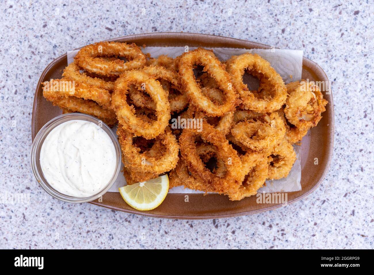 Top View of Crispy Fried Calamari Squid Rings with Lemon and Dipping Sauce Stock Photo