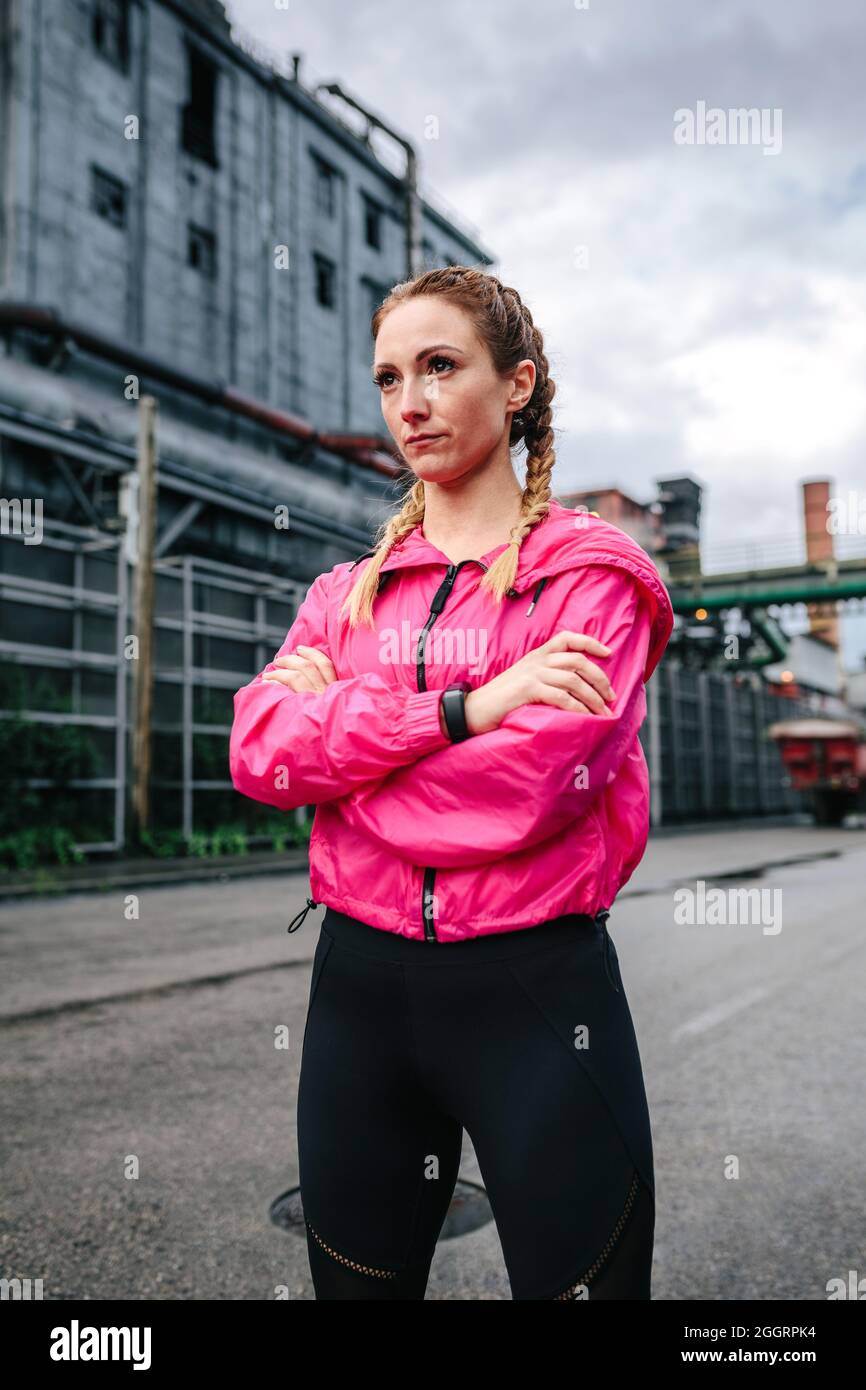 Sportswoman with boxer braids posing in front of a factory Stock Photo