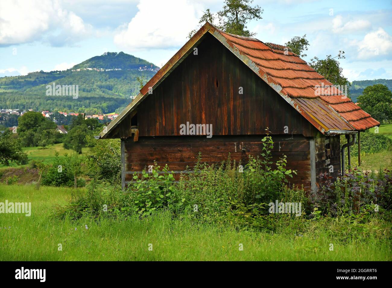 Old Barn With A Hill In The Background Stock Photo