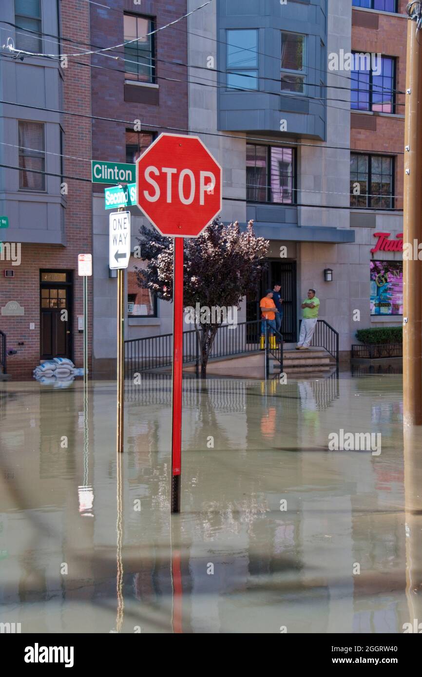 Workmen look over street flooding caused by Hurricane Ida in Hoboken, New Jersey, USA. Stock Photo