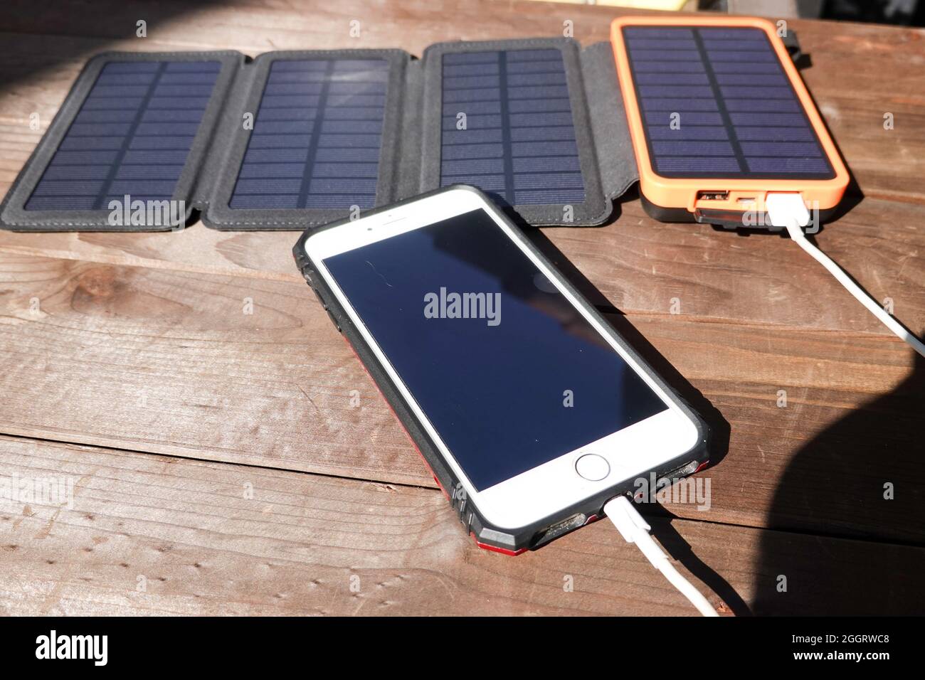 Portable solar panels with battery power bank storage charging a Iphone Stock Photo Alamy