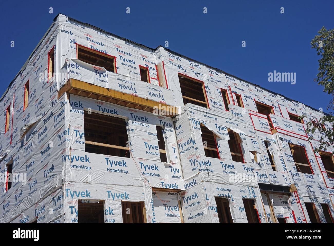Ontario, Canada - September 2, 2021:  House under construction, with the main frame nearing completion, covered with vapor barrier plastic wrap. Stock Photo
