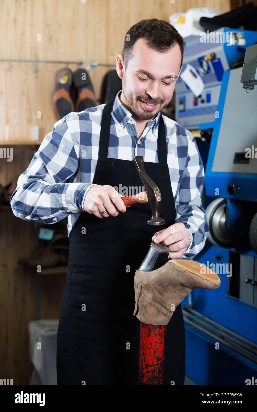Male worker repairing shoe Stock Photo
