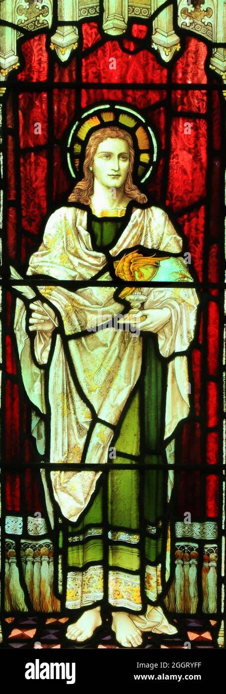 Saint John, holding wine cup, goblet, glass, with snake, stained glass window, saints, Snettisham church, Norfolk, England Stock Photo