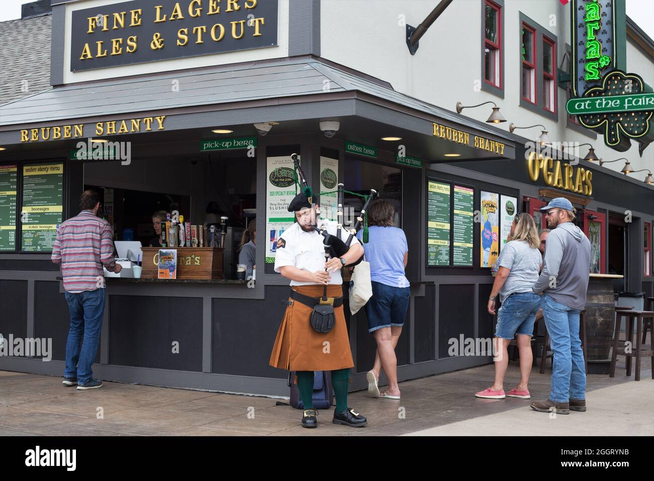 A man playing bagpipes in front of an Irish pub at the Minnesota State Fair. Stock Photo