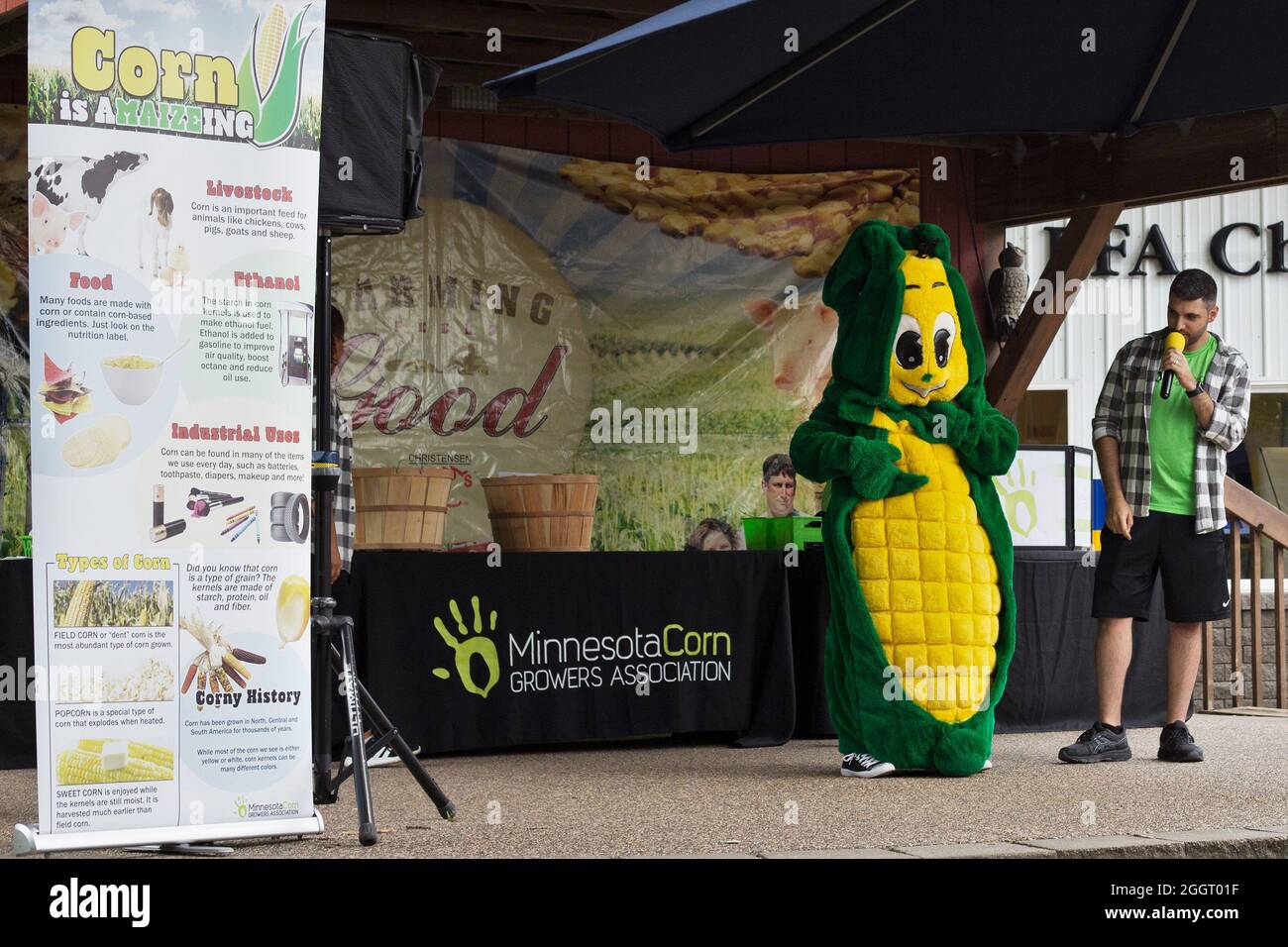 A man and a person in a corn costume give a presentation on corn, at