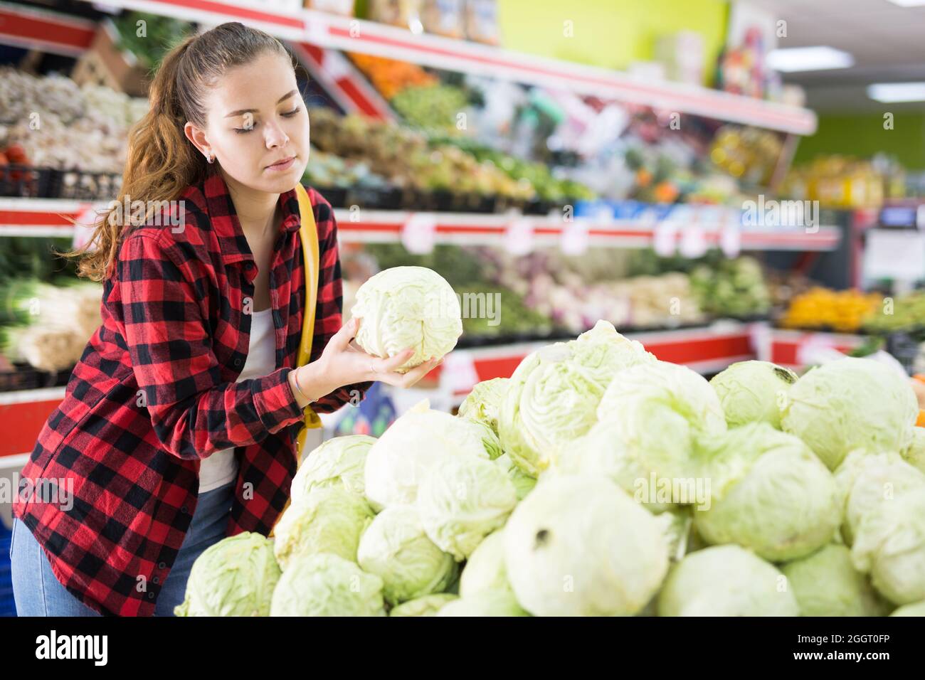 Positive customer chooses cabbages at grocery store Stock Photo Alamy