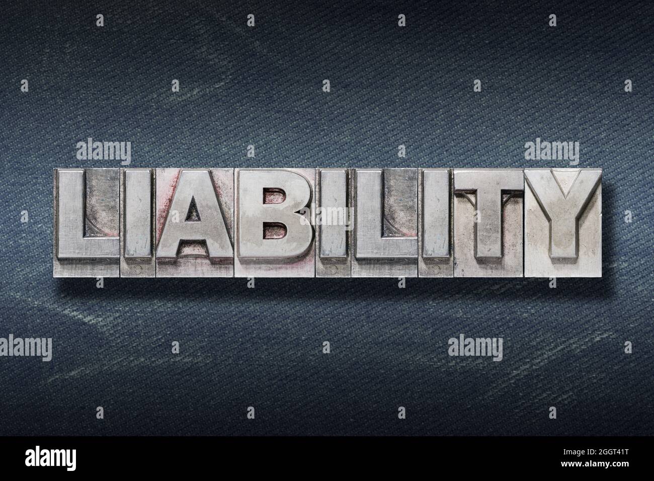 liability word made from metallic letterpress on dark jeans background Stock Photo
