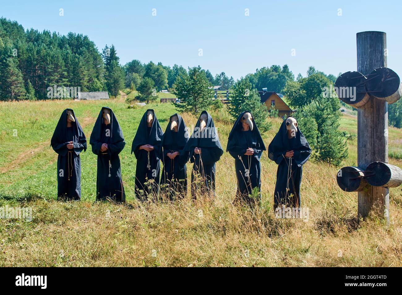 a group of people are standing in the masks of the plague doctor Stock Photo
