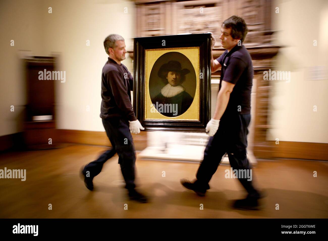 File photo dated 06/04/17 art technicians Andy Cavanagh (left) and Paul McCall moving a painting entitled 'Self Portrait' (1632) by Rembrandt at the Burrell Collection, Glasgow prior to the museum renovation. An art collection amassed by a shipping magnate is to go back on show to the public in March next year after a £68.25 million museum renovation. Issue date: Friday September 3, 2021. Stock Photo