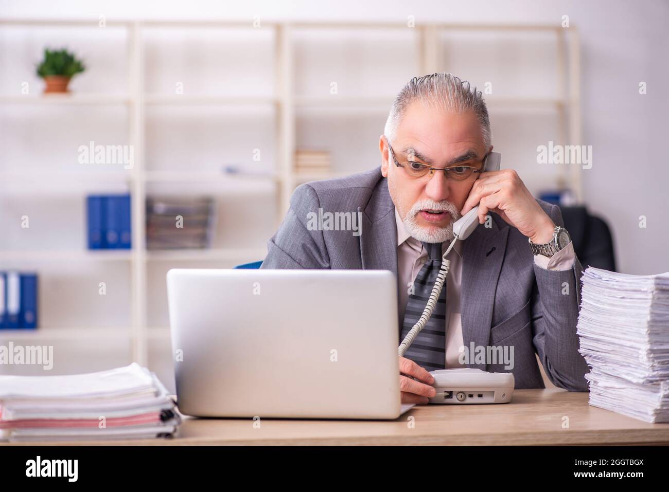 Old businessman employee working at workplace Stock Photo - Alamy