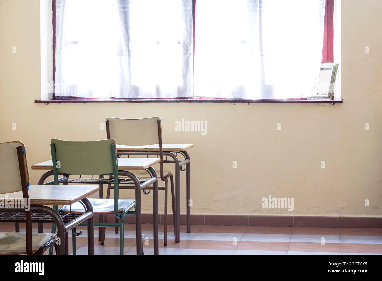 Photograph of some desks and chairs in a nursery school.The photo is taken in horizontal format. Stock Photo