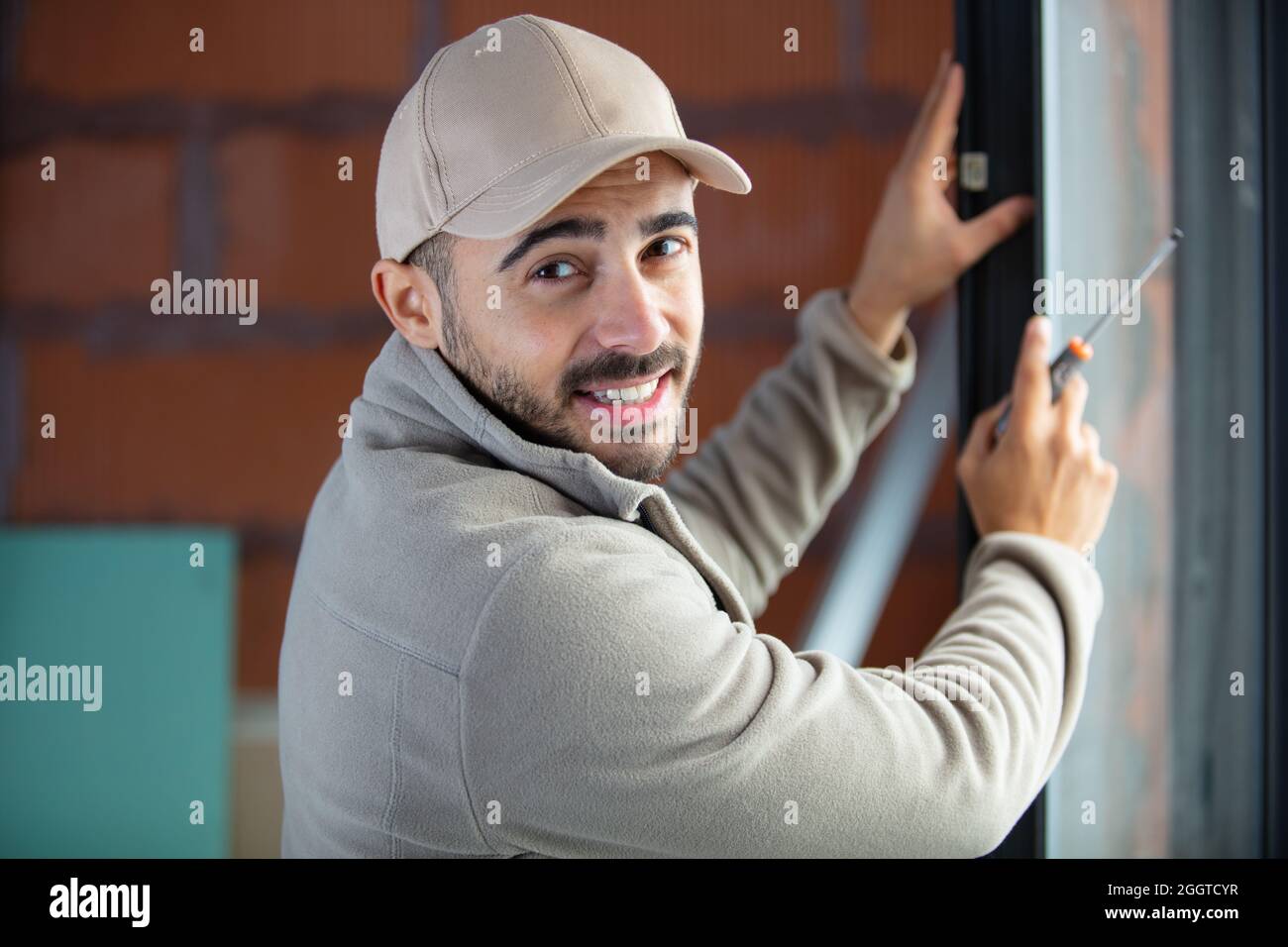 man installing roller shutter on window Stock Photo