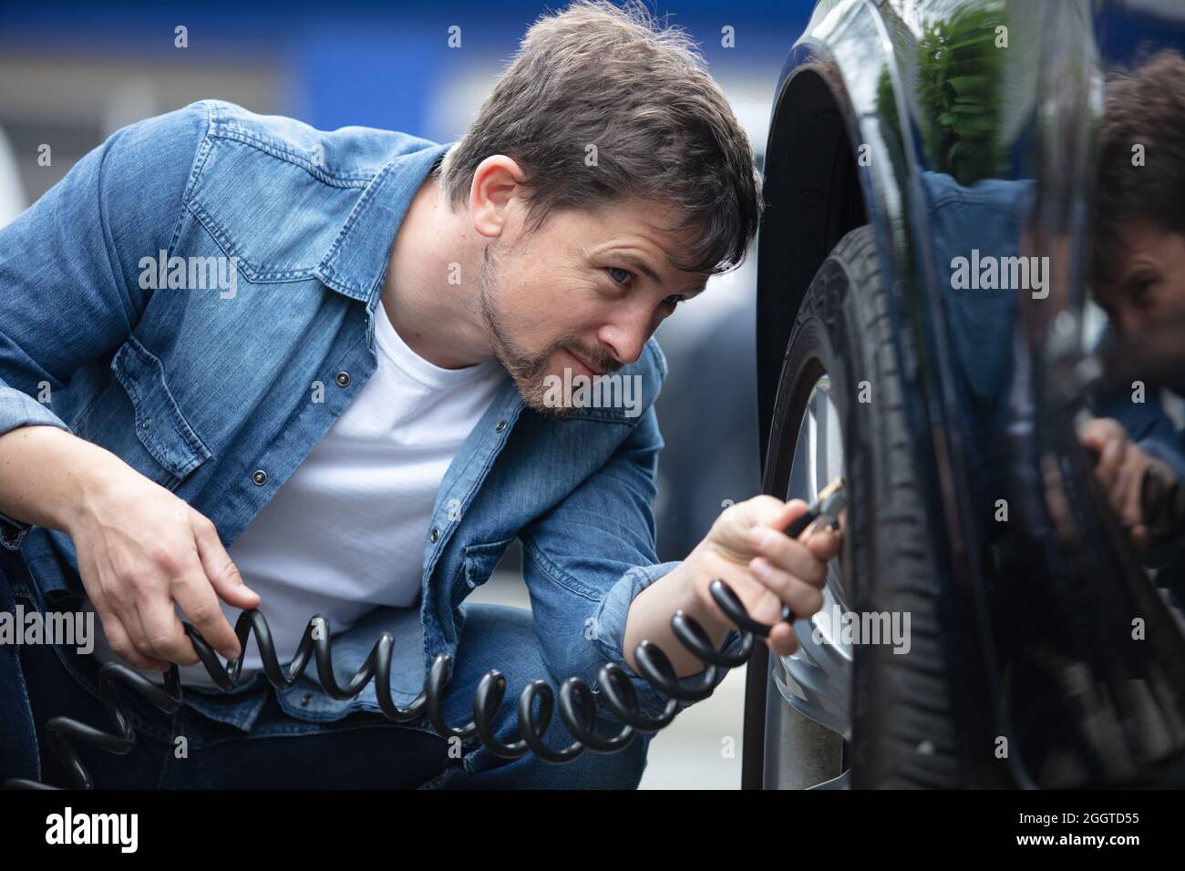 man holding portable pressure gauge for car tyre pressure measurement ...
