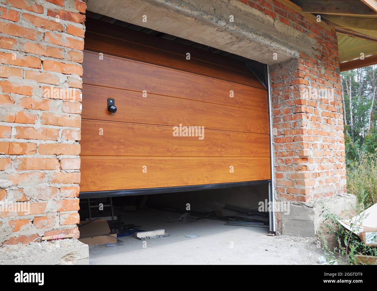 Installing garage door in new brick house construction Stock Photo Alamy