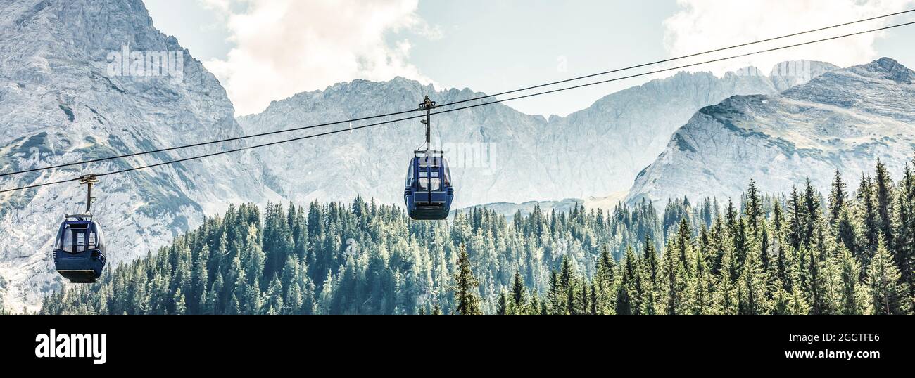 Two cabs of the cableway and skiers on the slope of the mountain Chopok