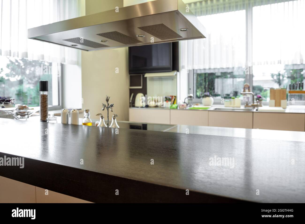 Wooden tabletop and cooker hood on blurred background of kitchen interior Stock Photo Alamy