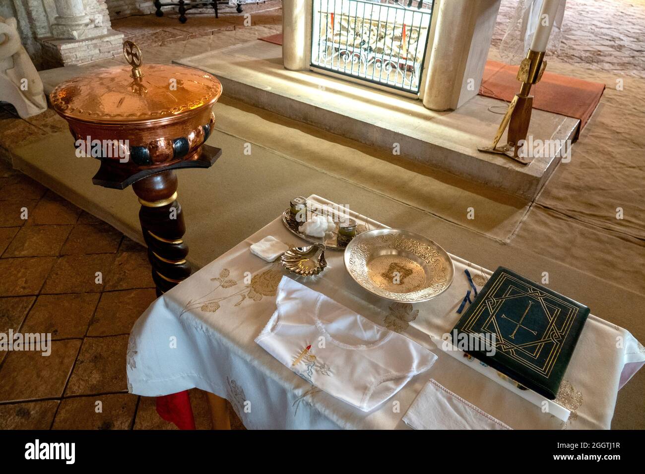 The baptismal font and liturgical instruments are ready for a baptism in the Crypt of the Cathedral of San Giustino, Chieti, Italy Stock Photo