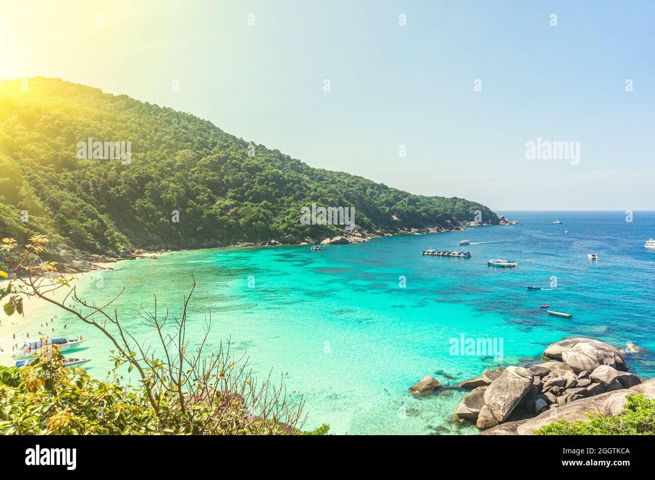 A beautiful lagoon of the blue sea near the coast with mountains. A tourist beach with white sand. Stock Photo