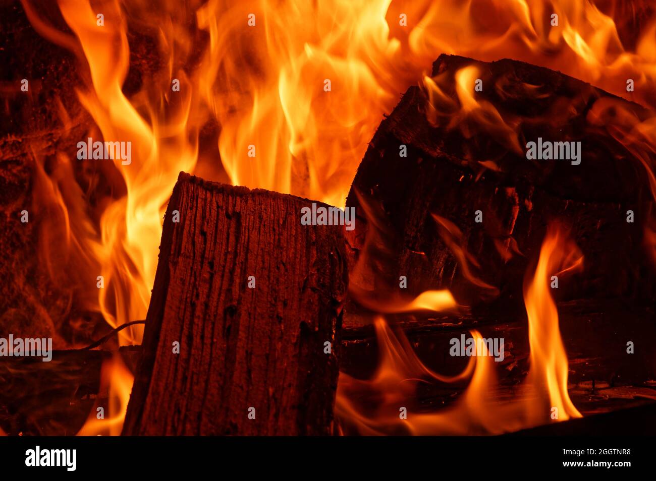 An open fire place is fueled with slabs of wood as fuel Stock Photo