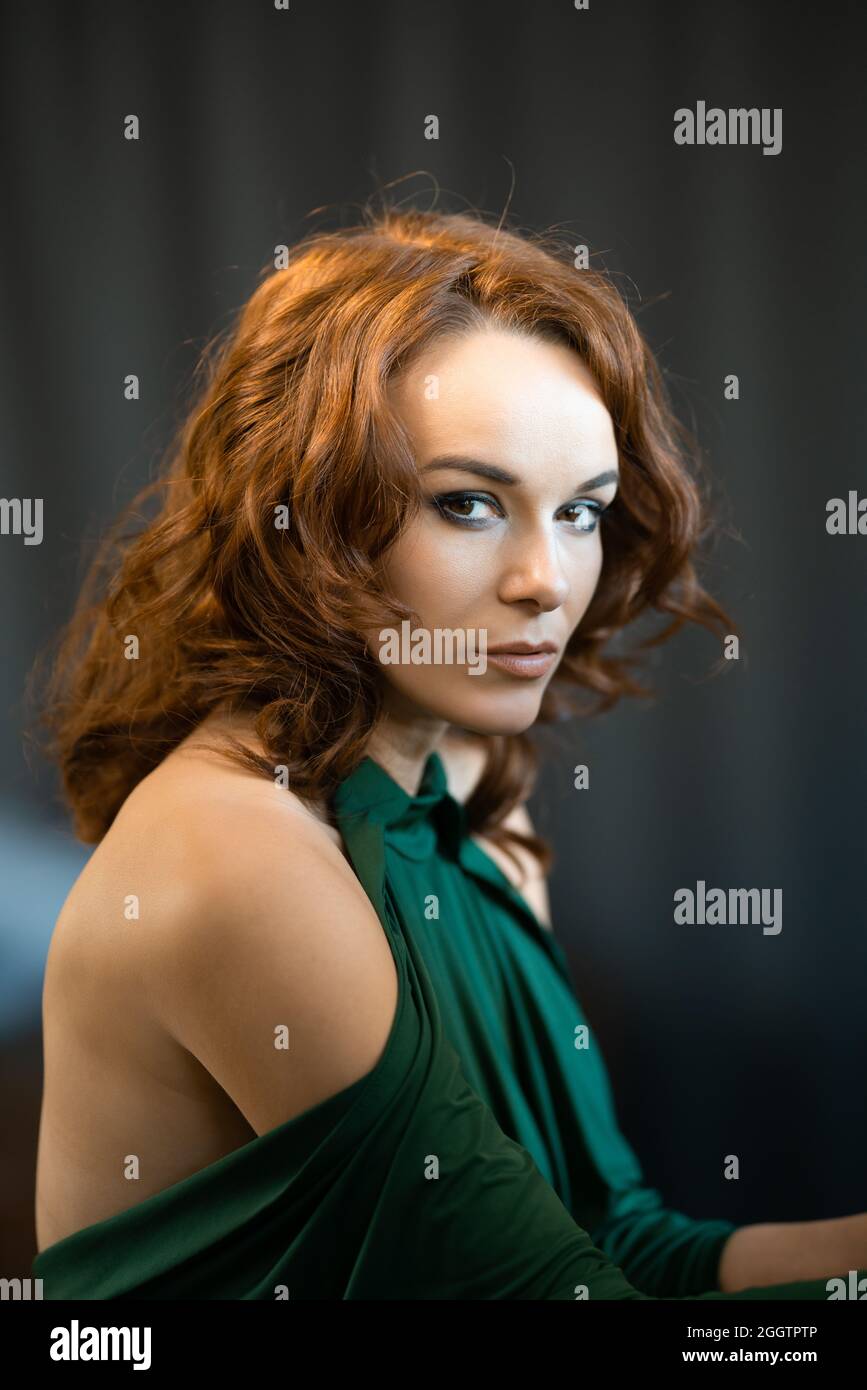 Portrait of a pretty female in green drees staring at the