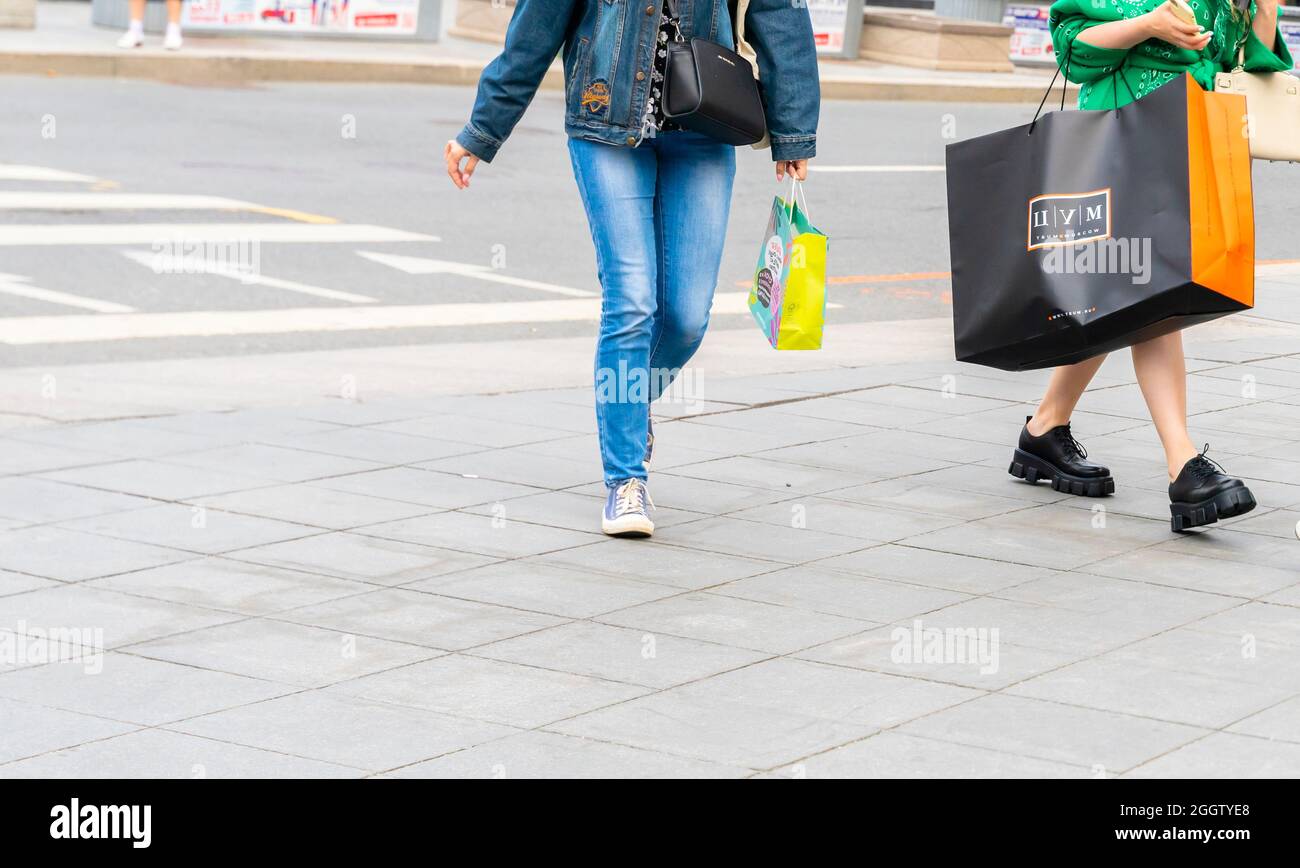 A woman carrying a large TSUM department store bag while walking, Moscow, Russia. Concept-consumerism, consumer economy, consumer spending. Stock Photo