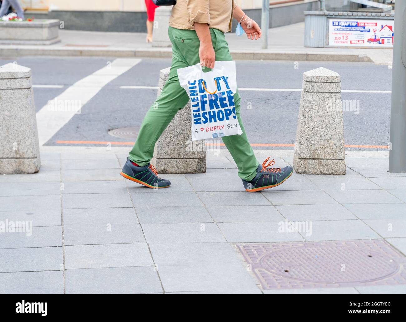 Person carrying a Hellenic Duty Free shop bag while walking, Moscow, Russia. Concept-consumerism, consumer economy, consumer spending. Stock Photo