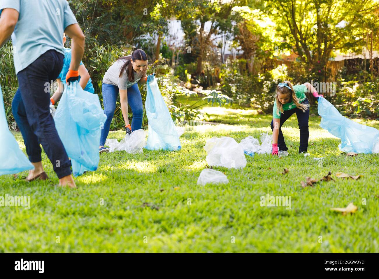 Caucasian parents, son and daughter putting rubbish in refuse sacks in the countryside Stock Photo