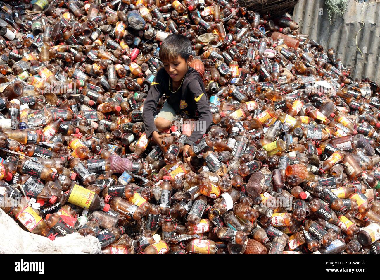 Laborers sort through polyethylene terephthalate (PET) bottles in a recycling factory in Dhaka