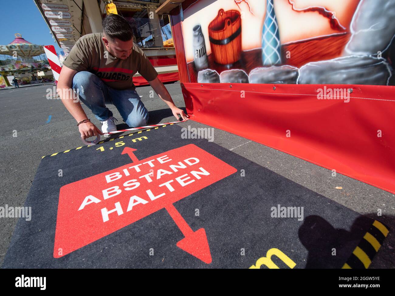 03 September 2021, Hessen, Frankfurt/Main: The employee of a snack bar prepares for the opening of the traditional folk festival in the afternoon at the Dippemess in Frankfurt. The Dippemess is allowed to open under special Corona conditions for a limited number of visitors. Photo: Boris Roessler/dpa Stock Photo