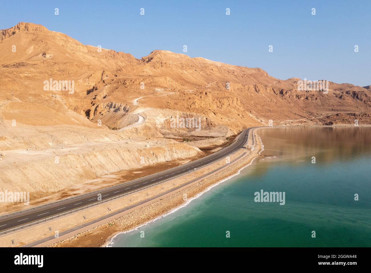 Dead Sea coastline and highway with desert mountains, Aerial view. Stock Photo