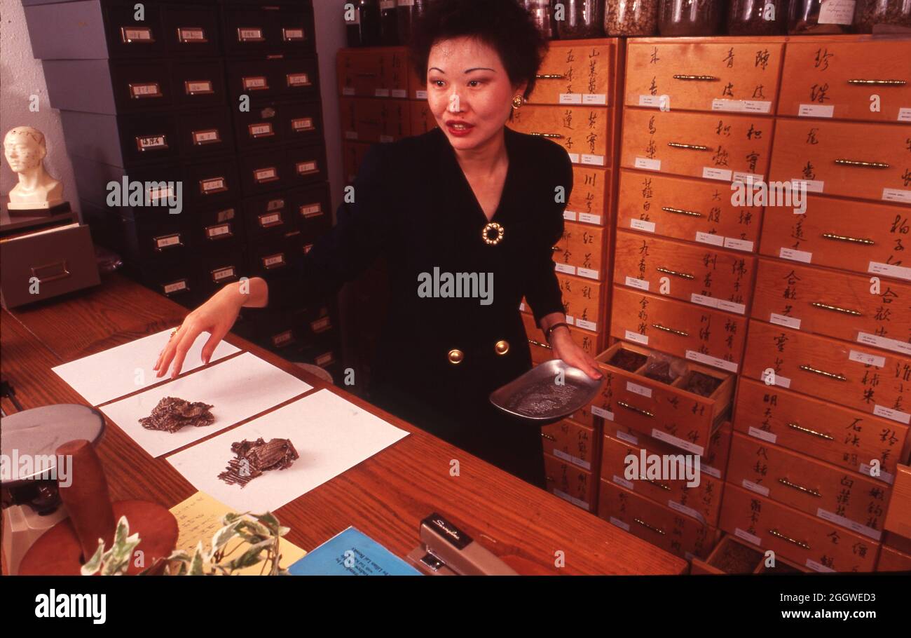 Austin Texas USA, circa 1992 Woman unscrews lid on jar of herbs at a