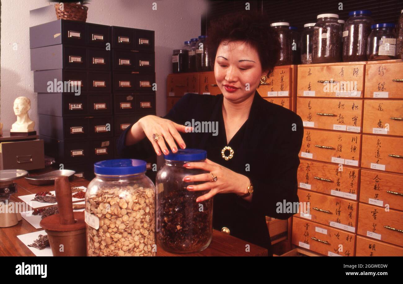 Austin Texas USA, circa 1992 Woman unscrews lid on jar of herbs at a