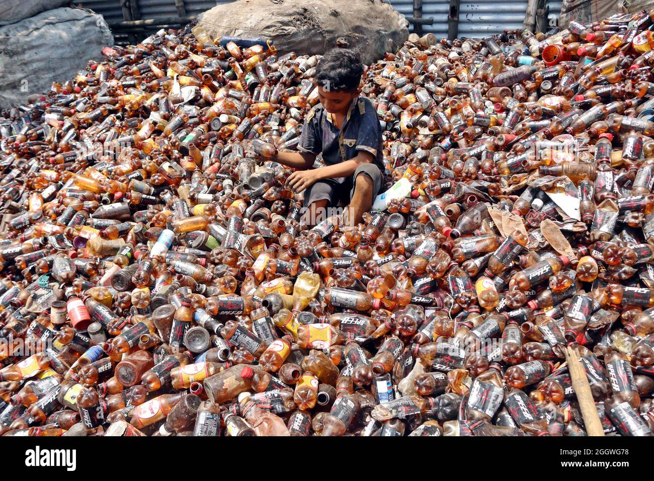 Dhaka, Bangladesh, 03/09/2021, A child separates bottles polyethylene terephthalate (PET) in a
