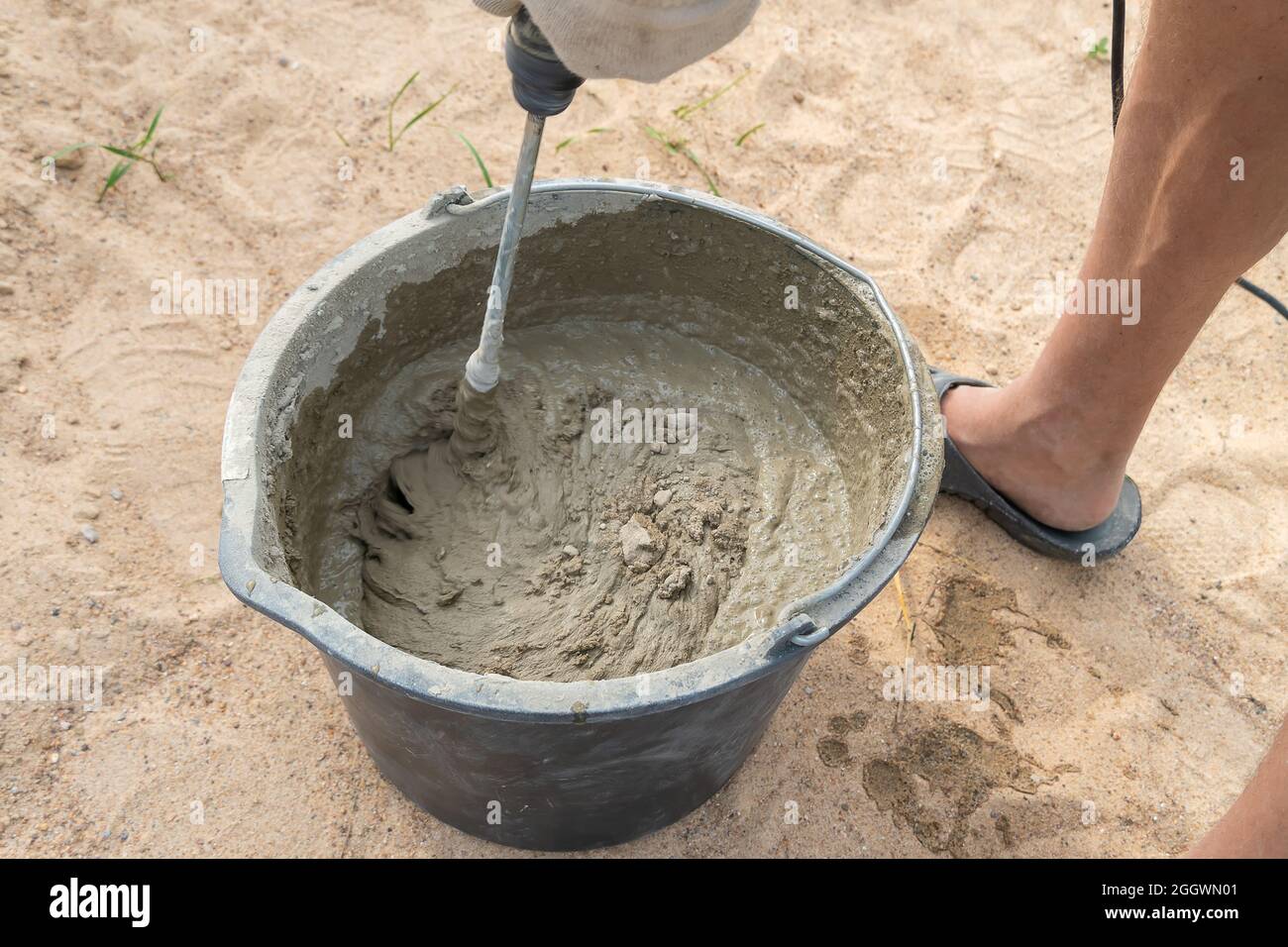 Mixing cement mortar in a bucket with an electric construction drill