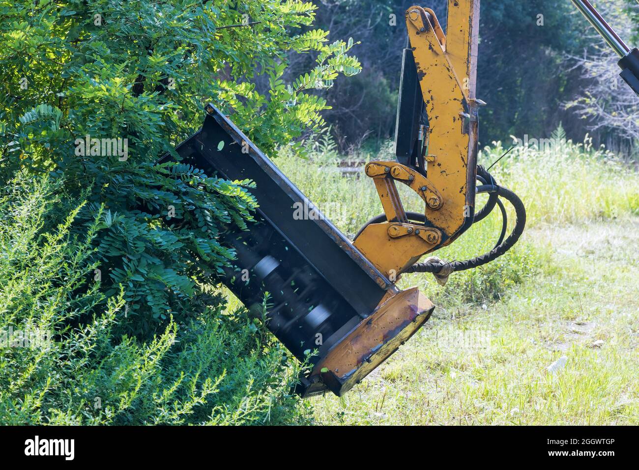 Suburban highway road maintenance service of tractor mechanization machine mower mowing grass Stock Photo