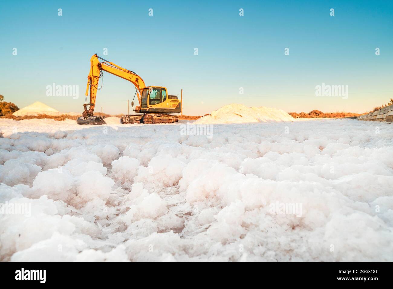 Sea salt harvest with yellow digger at salines in Faro, Algarve