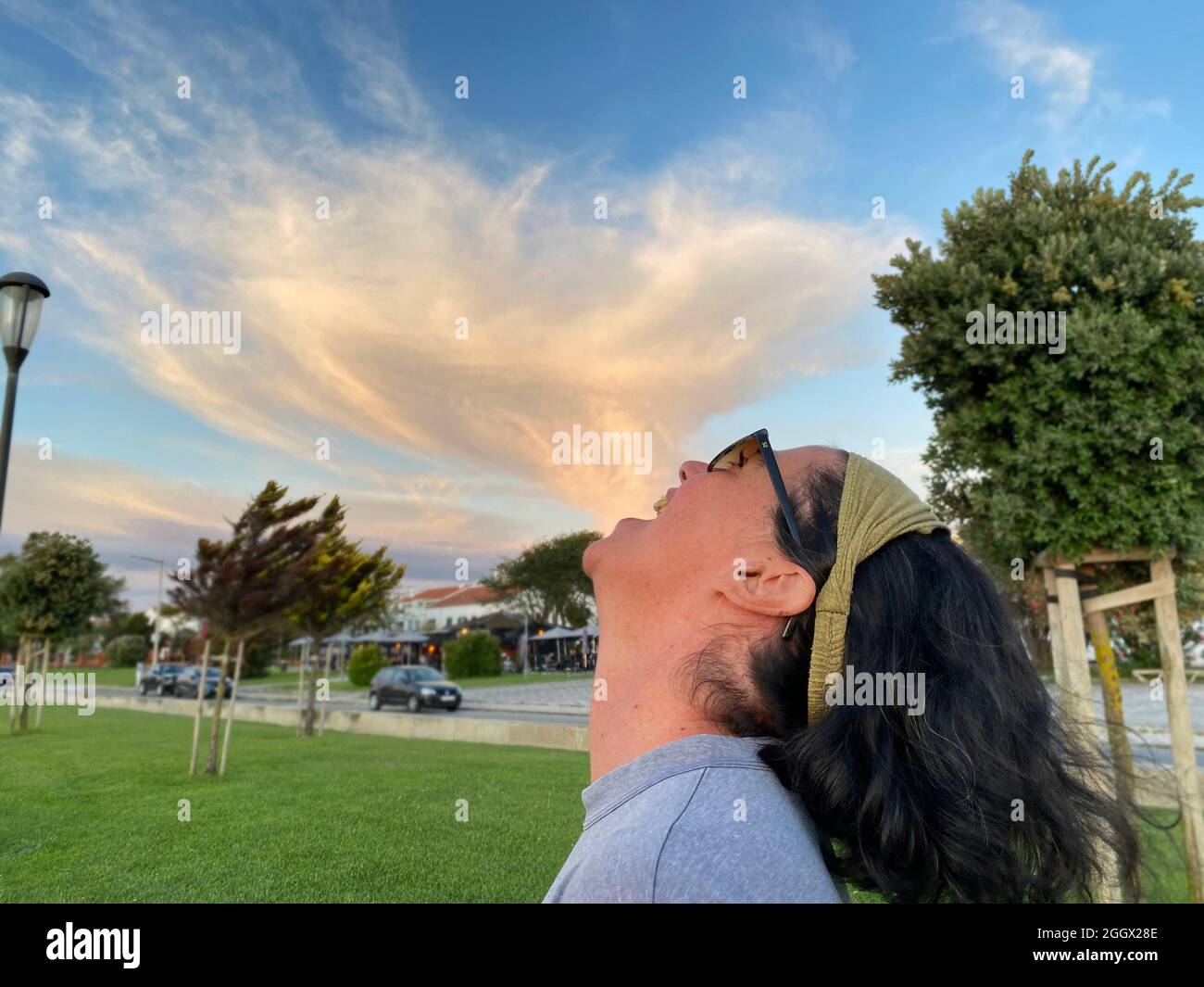 Optical illusion of woman eating a cloud. Stock Photo