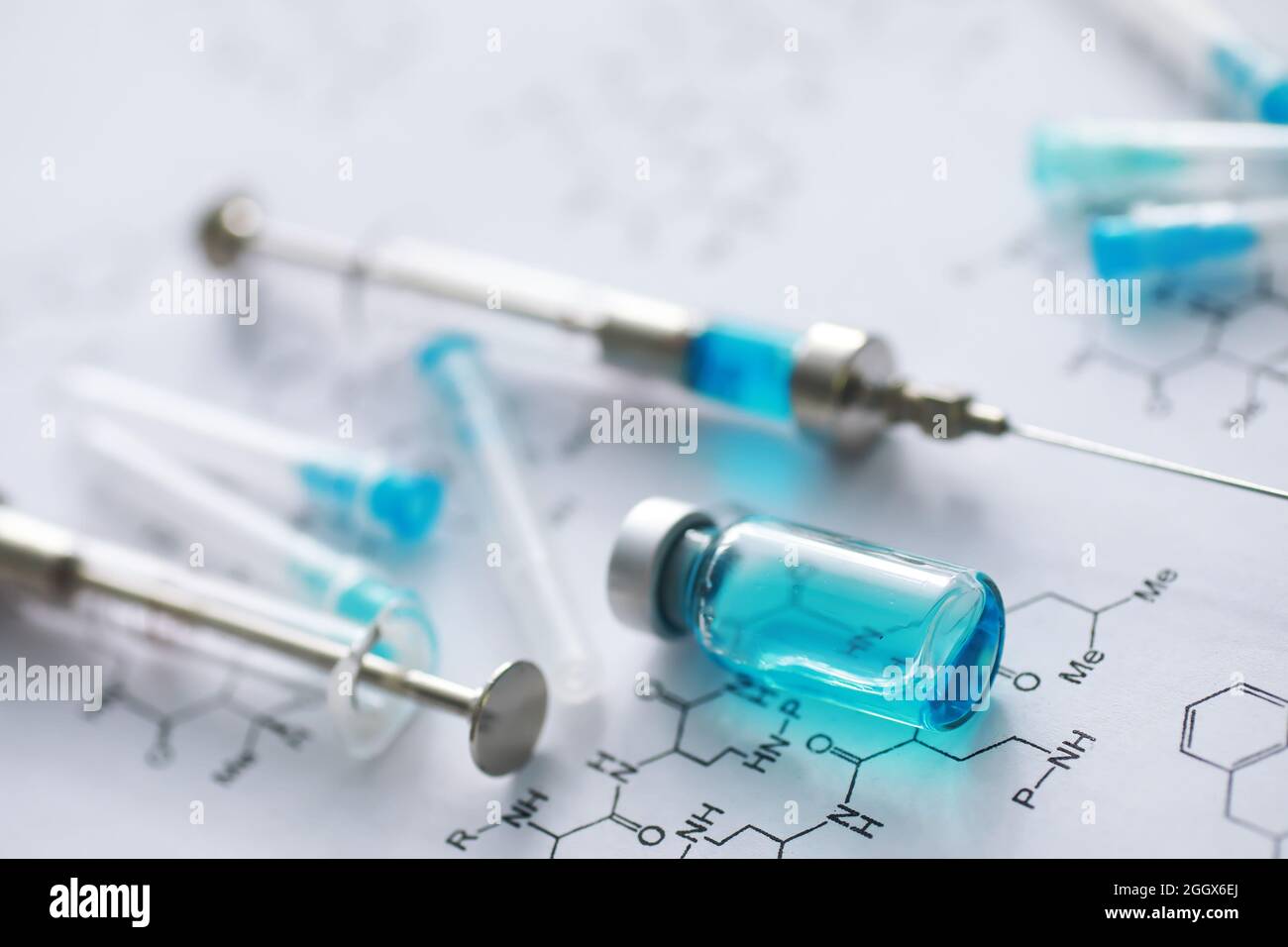 small jars with injection and syringe for injection on blue background ...