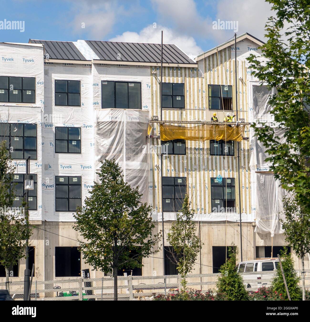 Workers on a scaffold working on new construction Stock Photo