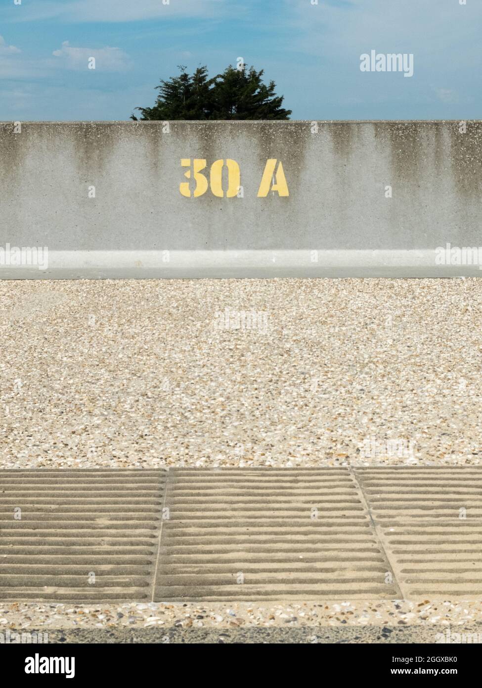 Stencilled yellow paint number 30A on a concrete sea wall Stock Photo