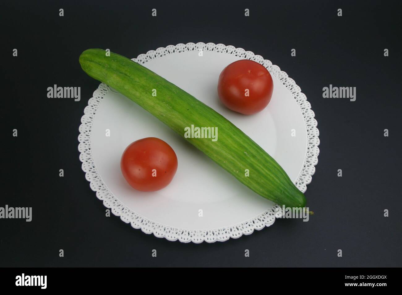 Essen Früchte Gurge und Tomaten auf einen weißen Teller Stock Photo