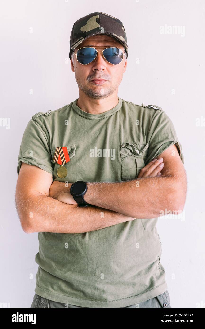 Military man with camouflage cap and sunglasses, decorated, with ...