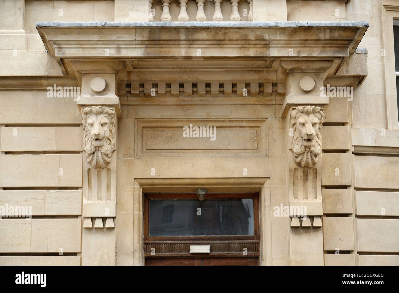 A grand entrance to a stone building. Carved sandstone lions heads. Stock Photo