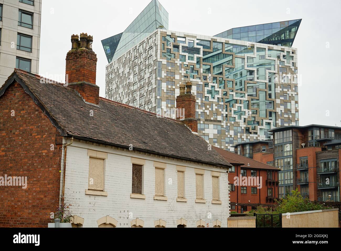 Old housing (Victorian) and modern The Cube, Birmingham building behind. Stock Photo