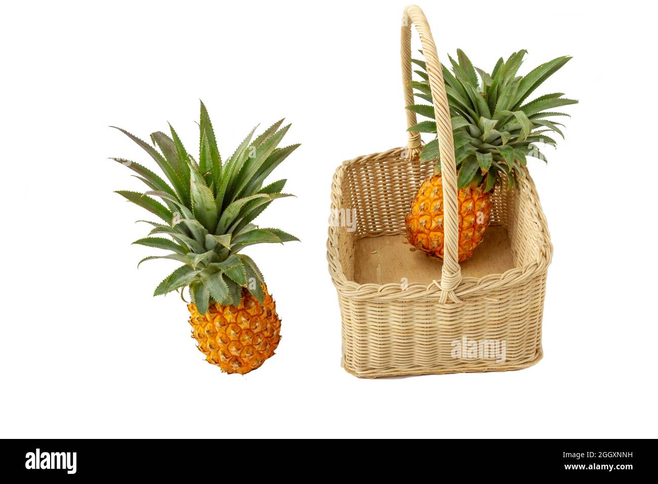 isolated pineapple fruit in white background with clipping path, two yellow pineapples in a fruit basket Stock Photo