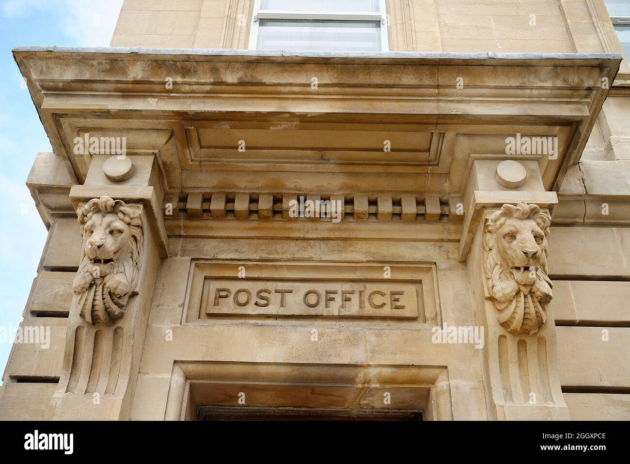 An old Post Office entrance doorway or portico. A grand stone facade with carved stone lions. A regal and important place to go. Stock Photo